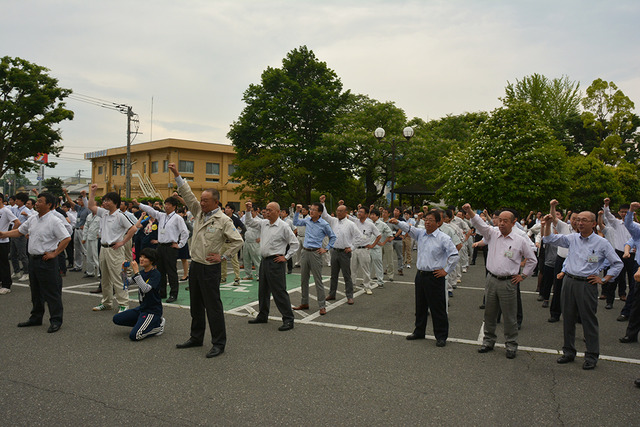 市役所前にてチャレンジデー実行委員会齋城副会長からの勝どきで参加者全員が手を挙げている写真